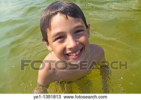 Smiling young boy swimming in the sea View Large Photo Image Stock Image - Smiling young boy swimming in the sea. Fotosearch