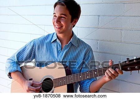 Smiling young man playing the guitar View Large Photo Image Stock Photo - Smiling young man playing the guitar. Fotosearch