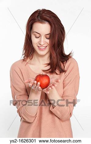 Smiling young woman holding apple View Large Photo Image Stock Image - Smiling young woman holding apple. Fotosearch