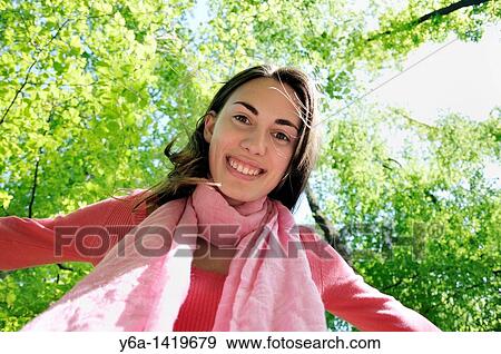 Stock Photo - Smiling young woman in woods. Fotosearch