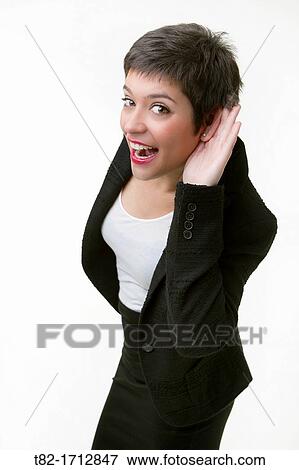 Smiling young woman listening intently on a white background View Large Photo Image Stock Photo - Smiling young woman listening intently on a white background. Fotosearch
