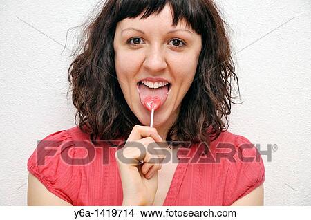 Picture - Smiling young woman with lollypop. Fotosearch