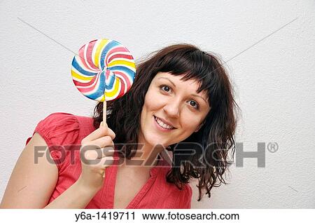 Smiling young woman with lollypop View Large Photo Image Stock Image - Smiling young woman with lollypop. Fotosearch