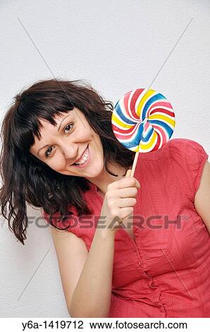 Smiling young woman with lollypop View Large Photo Image Stock Image - Smiling young woman with lollypop. Fotosearch
