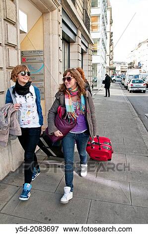 smiling young women - travelers pulling suitcases, street near main train station, Geneva, Switzerland View Large Photo Image Stock Photo - smiling young women - travelers pulling suitcases, street near main train station, Geneva, Switzerland. Fotosearch