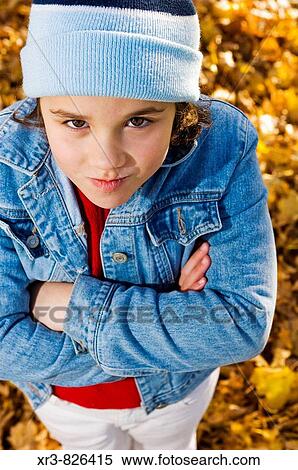 Smirking caucasian female child wearing a stocking cap and jean jacket looks up to the camera with attitude View Large Photo Image Stock Photography - Smirking caucasian female child wearing a stocking cap and jean jacket looks up to the camera with attitude. Fotosearch