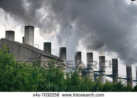 Stock Photo - Smoke bellows from somestacks at a Mexican sugar refinery. Fotosearch