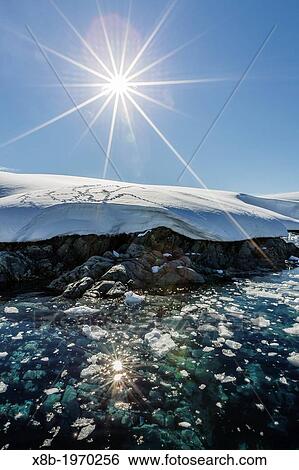 Stock Photograph - Snow-capped mountains surround the Enterprise Islands, Antarctica, Southern Ocean.. Fotosearch