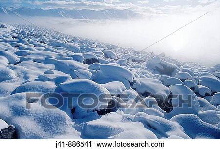 Stock Image - Snow-covered boulders on the edge of Lake Pukaki Mackenzie Basin New Zealand. Fotosearch