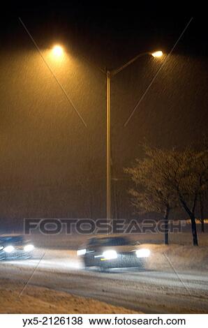 Stock Photo - Snow falling on a deserted street at night in Toronto suburbs.. Fotosearch