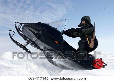 Stock Photography - Snow machine on frozen sea ice of Hudson Bay in late winter. Churchill, Manitoba, Canada.. Fotosearch