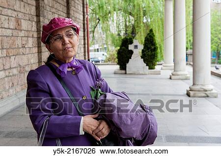 Stock Photograph - Sofia, Bulgaria. Orthodox-Christian female visitor to the Svetja Nedelya church, down town Sofia, telling about the history of this particular church building.. Fotosearch