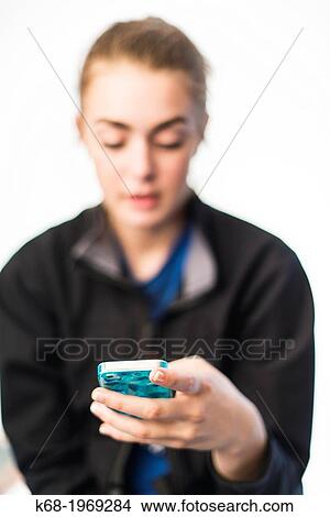 Picture - Soft focus of a girl, 17, using a smart phone. Fotosearch