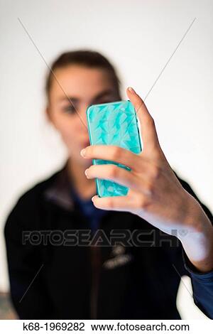 Soft focus of a girl, 17, using a smart phone View Large Photo Image Stock Image - Soft focus of a girl, 17, using a smart phone. Fotosearch