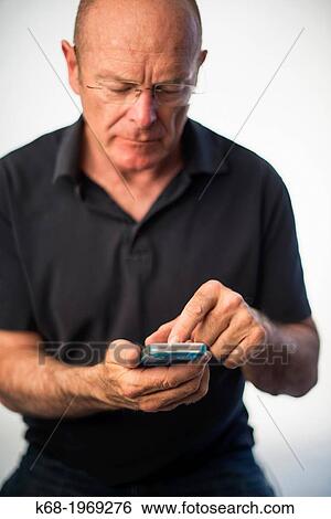 Soft focus on a smart phone, used by a middle-aged man View Large Photo Image Stock Photograph - Soft focus on a smart phone, used by a middle-aged man. Fotosearch