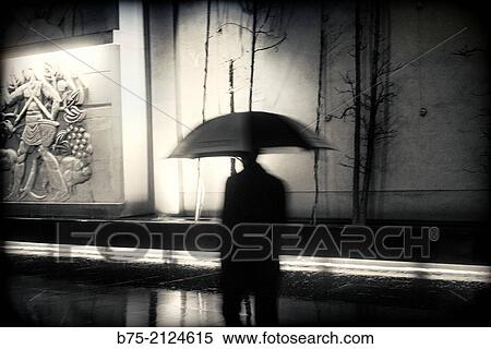 Solo and unrecognizable man walking around the city at night in the rain. London, England, UK, Europe. View Large Photo Image Stock Photography - Solo and unrecognizable man walking around the city at night in the rain. London, England, UK, Europe.. Fotosearch