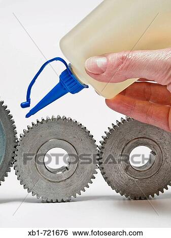 Stock Photograph - some old gear wheel greasing with a oilcan. Fotosearch