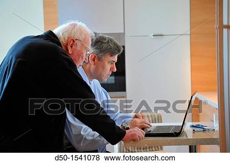 Son helping father with computer, Paris, France View Large Photo Image Stock Photo - Son helping father with computer, Paris, France. Fotosearch