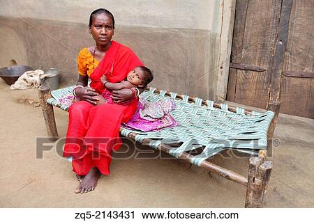 Soren Tribal woman in red sari sitting on a cot with her baby. Hardhekitand village, Dist Bokaro, Jharkhand, India. View Large Photo Image Stock Image - Soren Tribal woman in red sari sitting on a cot with her baby. Hardhekitand village, Dist Bokaro, Jharkhand, India.. Fotosearch