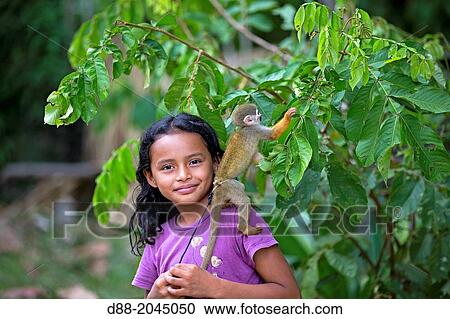 Stock Image - South America, Brazil, Amazonas state, Manaus, Amazon river basin, child and Common squirrel monkey (Saimiri sciureus).. Fotosearch