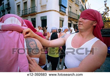 Stock Image - Spain. Andalusia. Sevilla. Small neighbourhood proud of the Virgin of Triana. Altar carriers with jesus tatoo. Fotosearch