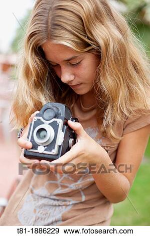 Spain, teenage girl looking at vintage camera View Large Photo Image Stock Photo - Spain, teenage girl looking at vintage camera. Fotosearch