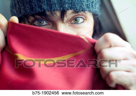 Stock Photograph - Spain, Woman covering her face and showing mystery look. Fotosearch