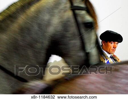 Stock Image - Spain's matador Manuel Jesus? El Cid? waits to enter to the bullring as horses passes during the Santiago bullfighting fair in Santander. Fotosearch