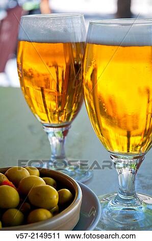 Spanish aperitif: two glasses of beer and green olives in a terrace. Spain. View Large Photo Image Stock Image - Spanish aperitif: two glasses of beer and green olives in a terrace. Spain.. Fotosearch