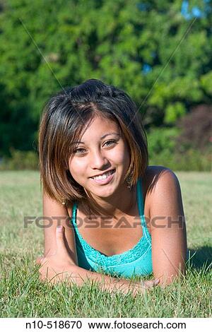 Spanish dark skin teen girl, lying on the grass at a park, posing View Large Photo Image Stock Image - Spanish dark skin teen girl, lying on the grass at a park, posing. Fotosearch