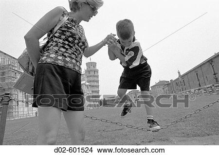 spanish mother helps her young son balance on chain fence in front of Leaning Tower of Pisa in Pisa, Italy View Large Photo Image Picture - spanish mother helps her young son balance on chain fence in front of Leaning Tower of Pisa in Pisa, Italy. Fotosearch