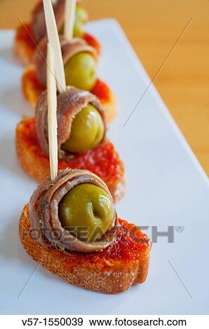 Spanish tapa: Anchovy fillets filled with green olive and bread with tomato sauce. Spain. View Large Photo Image Stock Photo - Spanish tapa: Anchovy fillets filled with green olive and bread with tomato sauce. Spain.. Fotosearch