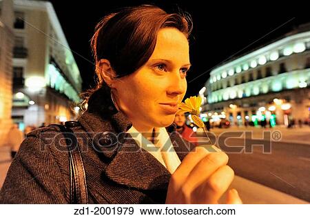 Spanish woman holding a flower in Plaza del Sol (Puerta del Sol) central square in Madrid Spain at night. View Large Photo Image Stock Photo - Spanish woman holding a flower in Plaza del Sol (Puerta del Sol) central square in Madrid Spain at night.. Fotosearch