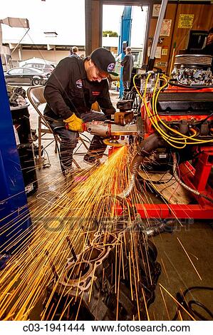 Sparks fly as a teenage boy grinds a metal engine fitting in auto shop class in San Clemente, CA. View Large Photo Image Picture - Sparks fly as a teenage boy grinds a metal engine fitting in auto shop class in San Clemente, CA.. Fotosearch