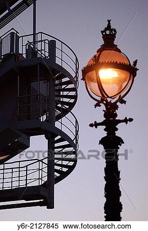 Spiral staircase on the London Eye seen at dusk with an ornate Victorian streetlight in the foreground, in the heart of London, England. View Large Photo Image Stock Photography - Spiral staircase on the London Eye seen at dusk with an ornate Victorian streetlight in the foreground, in the heart of London, England.. Fotosearch