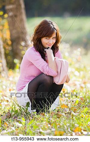 Squatting in grass fanciful young woman View Large Photo Image Stock Image - Squatting in grass fanciful young woman. Fotosearch
