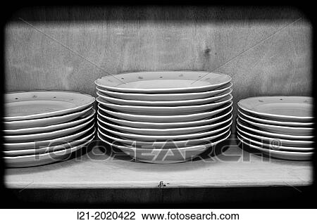 Stock Image - Stack of dishes in a cupboard.. Fotosearch