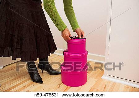 Stock Image - Stack of three pink gift boxes on a wooden floor.. Fotosearch