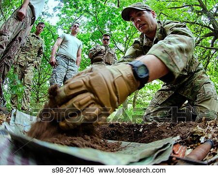 Staff Sgt. Jacob Schmidt, 352nd Special Operations Support Squadron survival, evasion, resistance and escape specialist, shows airmen from the 352nd Special Operations Group how to make a fire pit during combat survival training View Large Photo Image Stock Photography - Staff Sgt. Jacob Schmidt, 352nd Special Operations Support Squadron survival, evasion, resistance and escape specialist, shows airmen from the 352nd Special Operations Group how to make a fire pit during combat survival training. Fotosearch