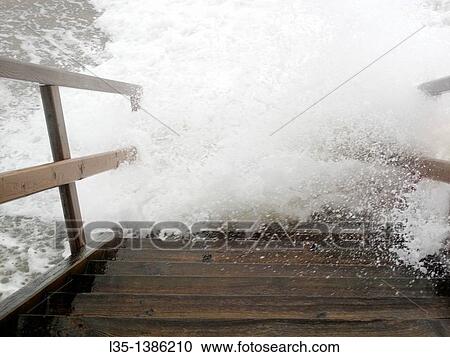 Stock Image - Stairs at the sea of roaring waves recorded, Sylt, Germany. Fotosearch