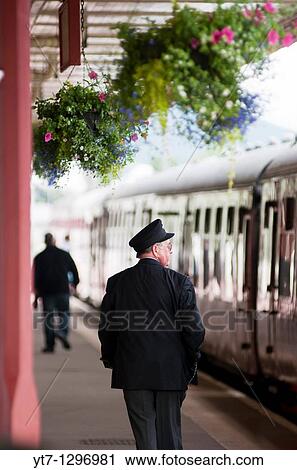 Station guard and carriages belonging to The Caledonian Railway Number 828 at Aviemore station in Scotland View Large Photo Image Stock Image - Station guard and carriages belonging to The Caledonian Railway Number 828 at Aviemore station in Scotland. Fotosearch