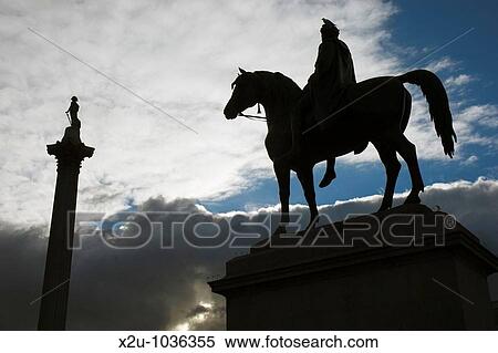 Stock Photography - Statue of King George IV on horseback and Nelson Column silhouetted against sunset, Trafalgar Square, London, England. Fotosearch