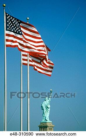Stock Image - Statue of Liberty and US flags. New York City. USA. Fotosearch