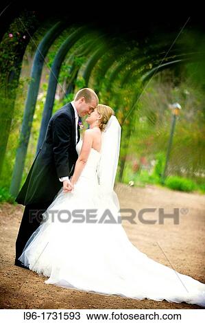 Stock Image - stealing a private moment at their garden reception. Fotosearch