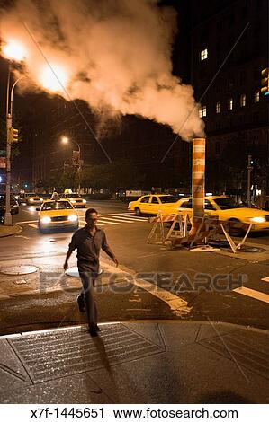 Stock Image - Steaming smoke stack, in Park Ave at 60 th st, New York City, USA. Fotosearch