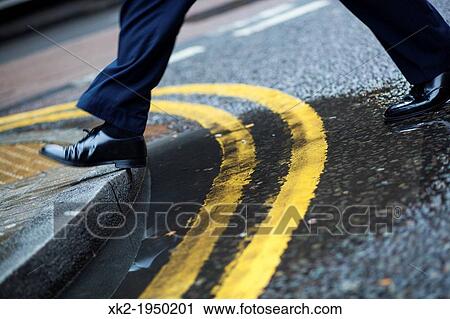 Step up to pavement, Businessman crossing the double yellow line, London, UK View Large Photo Image Stock Image - Step up to pavement, Businessman crossing the double yellow line, London, UK. Fotosearch