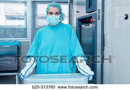 Stock Image - Sterilization works at surgery division of hospital. Fotosearch