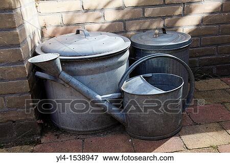 Still life of watering can and to vats in the garden. The Netherlands View Large Photo Image Stock Photo - Still life of watering can and to vats in the garden. The Netherlands. Fotosearch