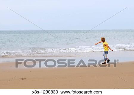 Stock photo of a 10 year old boy throwing stones into the sea View Large Photo Image Stock Image - Stock photo of a 10 year old boy throwing stones into the sea. Fotosearch