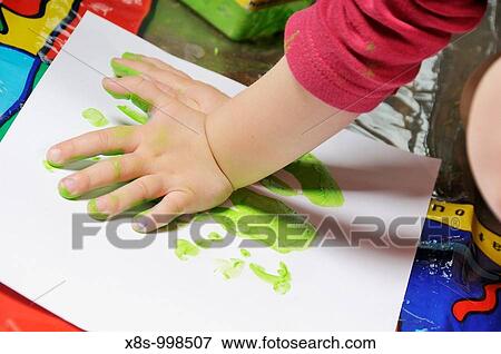 Stock Photo - Stock photo of a 3 year old girl doing some creative hand painting play. Fotosearch